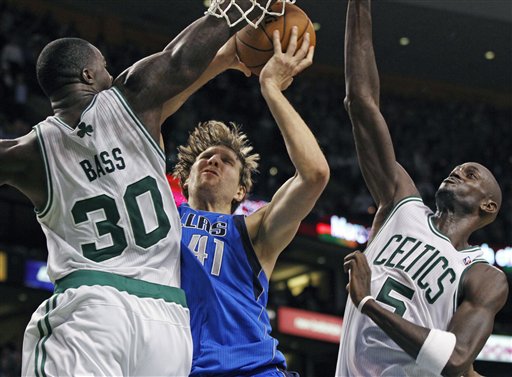 Dallas Mavericks forward Dirk Nowitzki (41) drives to the basket between Boston Celtics forward Brandon Bass (30) and forward Kevin Garnett (5) in the last seconds of an NBA basketball game in Boston, Wednesday, Jan. 11, 2012. Nowitzki scored and was fouled by Bass to make it a 3-point play. Dallas won 90-85. (AP Photo/Elise Amendola)