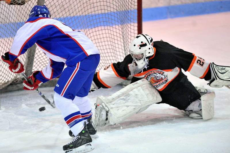 THAT’S IN: Messalonskee's Sam Dexter, left, scores a goal on Brunswick’s Jason Blier in the first period Wednesday at Sukee Arena in Winslow.