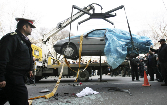 In this photo provided by the semi-official Fars News Agency, a crane removes the car of nuclear chemist Mostafa Ahmadi Roshanas today in Tehran,