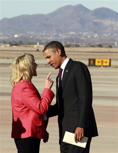 Arizona Gov. Jan Brewer points at President Barack Obama after he arrives at Phoenix-Mesa Gateway Airport on Wednesday. The two leaders engaged in an intense conversation at the base of Air Force One's steps and both could be seen smiling, but speaking at the same time. Asked moments later what the conversation was about, Brewer, a Republican, said: "He was a little disturbed about my book."