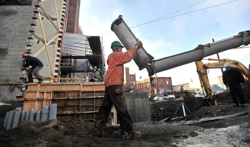 NEW FOUNDATION: Josh Allen, a worker for Sheridan Corporation adds a chute extension on to the boom of the concrete truck as crews pour part of a new foundation during construction for the stage addition at the Waterville Opera House recently.