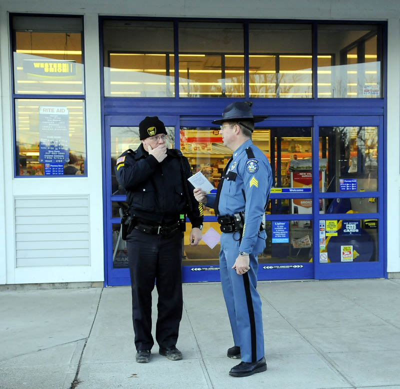 ROBBED: Gardiner Police Department Sgt. Stacey Blair, left, and Maine State Police Sgt. Michael Field talk Monday outside the RiteAid pharmacy in Gardiner moments after it was robbed.