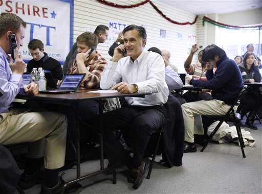 Republican presidential candidate Mitt Romney sits with volunteers to call likely voters ahead of Tuesday's primary election during a visit to his campaign headquarters in Manchester, N.H., today