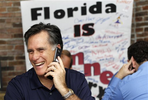 Mitt Romney speaks with a voter at his campaign office in Tampa today during Florida's primary election day.