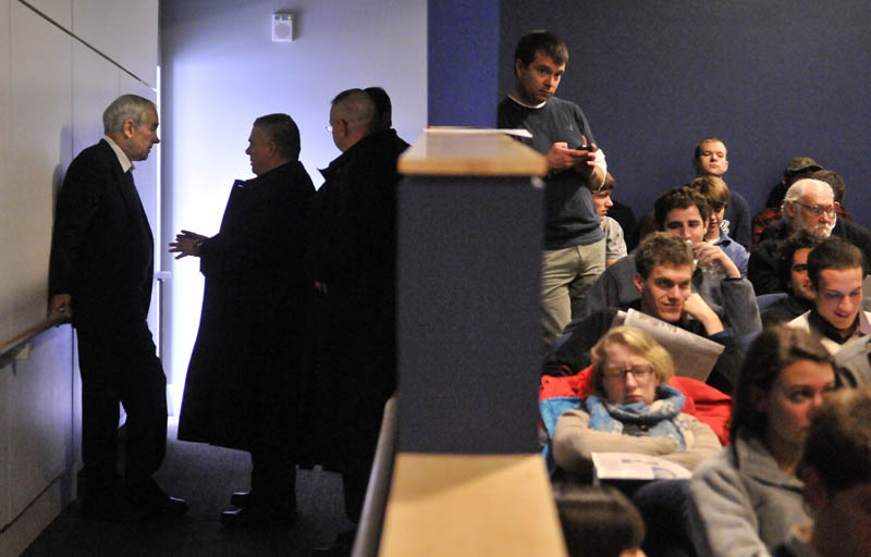 Staff photo by Michael G. Seamans Republican Party presidential hopeful, Ron Paul, far left, speaks with his security adviser in the wings of the Ostrove Auditorium at Colby College before speaking during a campaign visit on Friday.