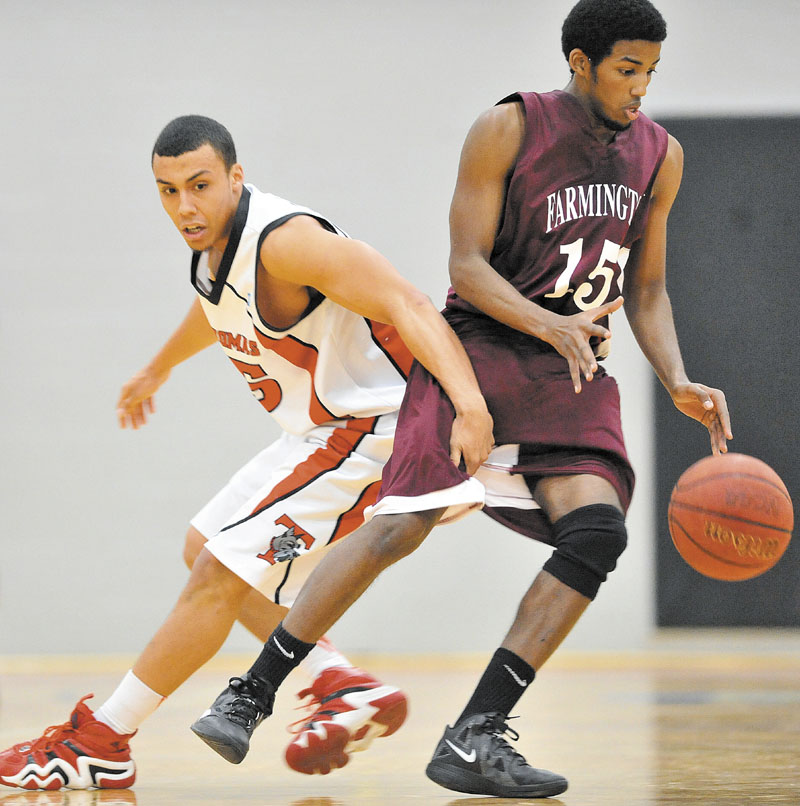 Thomas College's Ryan Newton, left, fouls University of Maine at Farmington's Yusuf Iman in the first half at Mahaney Gymnasium at Thomas College in Waterville Saturday. Thomas defeated UMF 81-73.