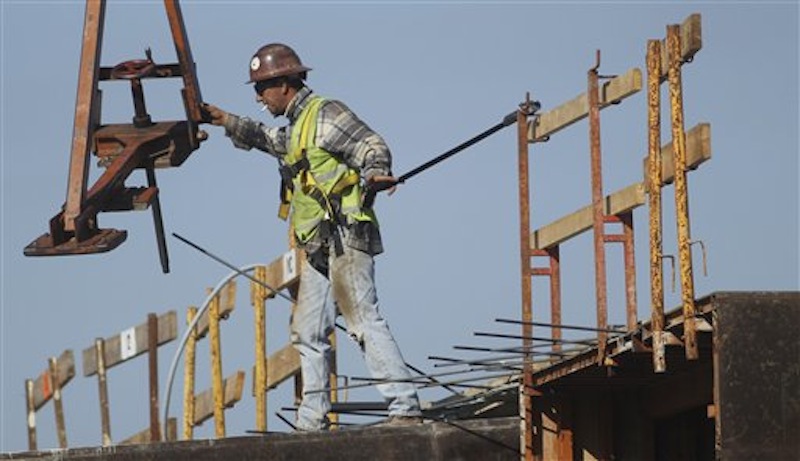 A construction worker directs a steel hoist at the foundation of a new condo complex in Sunrise, Fla. A burst of hiring in December pushed the unemployment rate to its lowest level in nearly three years. (AP Photo/J Pat Carter)
