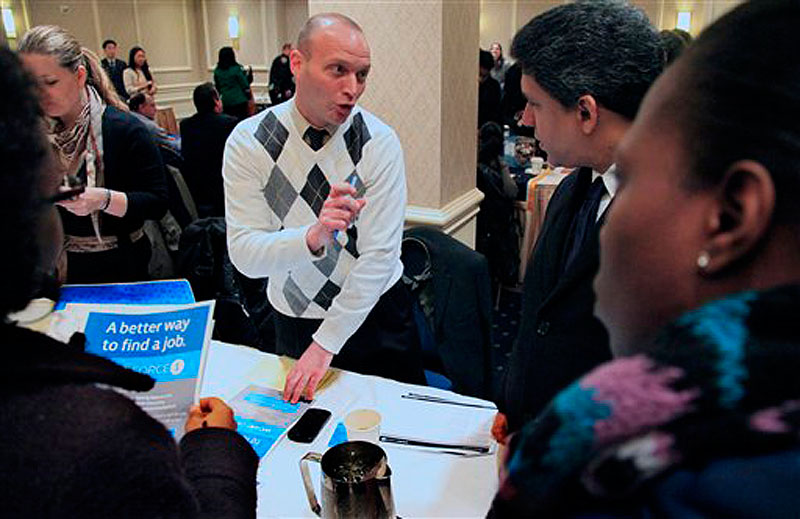 Jason Weinstein, an account manager for Workforce1 Healthcare, discusses job opportunities with attendees at JobEXPO's job fair on Wednesday, Jan. 25, 2012 in New York. (AP Photo/Bebeto Matthews)
