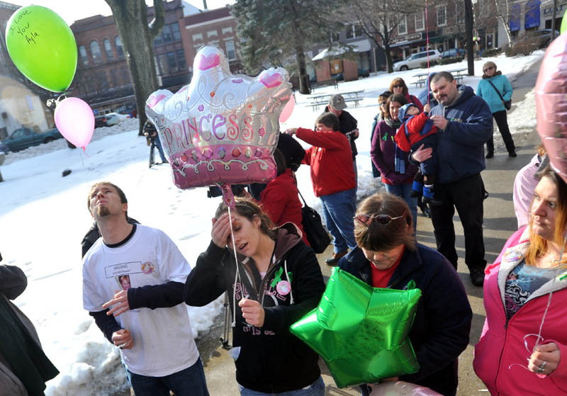 Staff photo by Michael G. Seamans Justin DePietro, far left, Trista Reynolds, center left, parents of missing toddler Ayla Reynolds, release balloons during a vigil in Castonguay Square in Waterville. Becca Hanson, right center, mother of Trista Reynolds, and Amanda Benner, far right, friend of Trista Reynolds, also are seen.