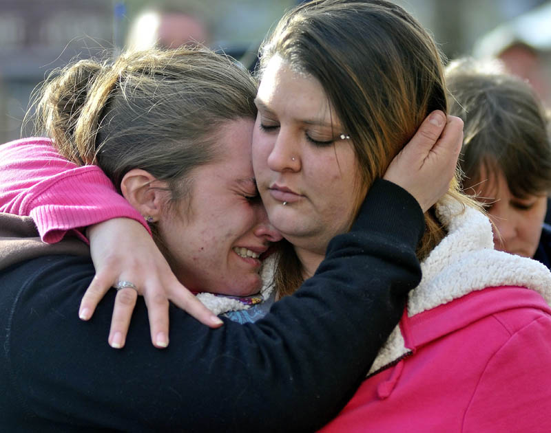 COMFORT: Trista Reynolds, left, is comforted by her friend Amanda Benner during a vigil for missing toddler Ayla Reynolds in Castonguay Square in Waterville on Saturday.