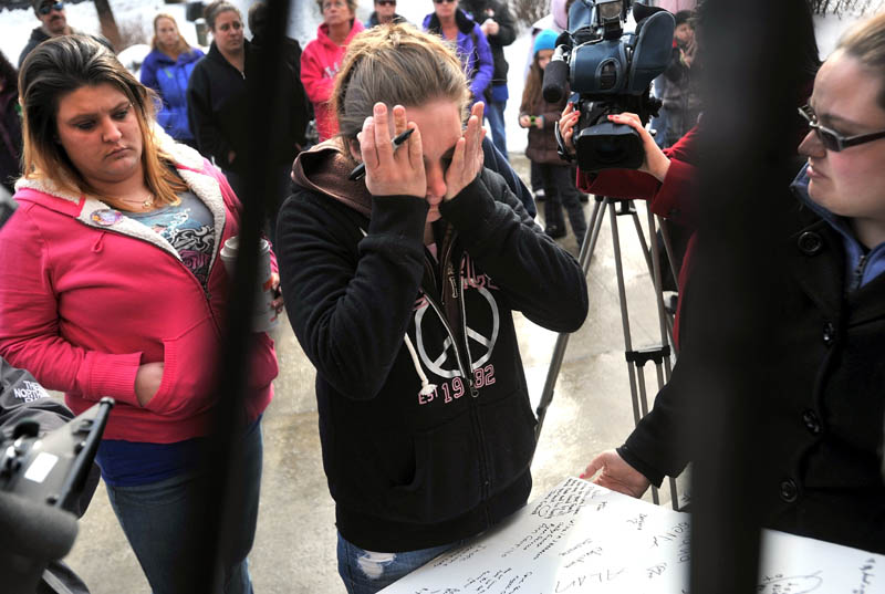 Staff photo by Michael G. Seamans Trista Reynolds, center, is over come with grief after writing a message for her missing toddler, Ayla Reynolds, during a vigil in Castonguay Square in Waterville Saturday.