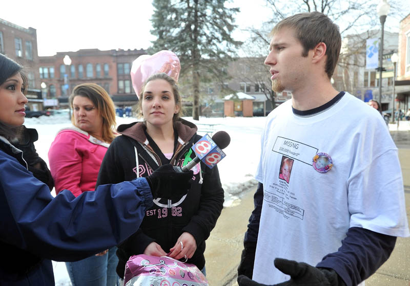 Staff photo by Michael G. Seamans Trista Reynolds, center, and Justin DePietro, right, parents of missing toddler, Ayla Reynolds, talk with media during a vigil in Castonguay Square in Waterville Saturday.