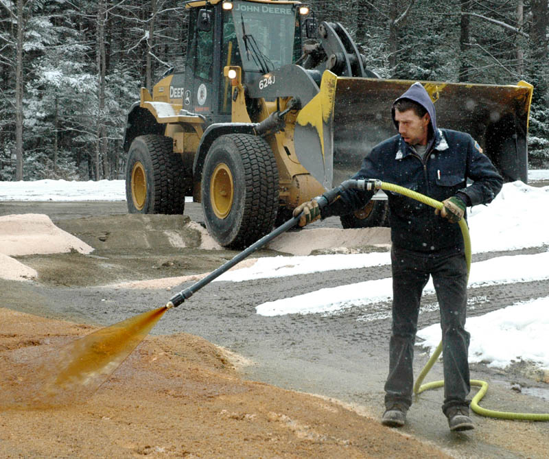 Bob Corrigan of the Skowhegan Highway Department sprays Ice B’Gone, a road de-icer made from beet molasses mixed with road salt at the town sand-and-salt yard recently.