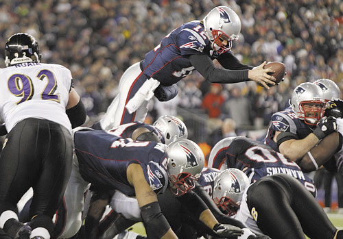 UP AND OVER: New England Patriots quarterback Tom Brady (12) dives over the middle to score on a 1-yard run against the Baltimore Ravens during the AFC Championship game Sunday in Foxborough, Mass.
