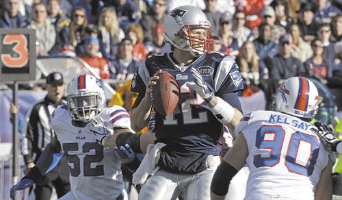 BIG GAME: New England Patriots quarterback Tom Brady (12) looks to pass as Buffalo Bills linebackers Chris Kelsay (90) and Arthur Moats (52) close in during the first quarter Sunday in Foxborough, Mass. Brady threw for 338 yards, finishing the regular season with the second most yards passing in NFL history, 5,235.