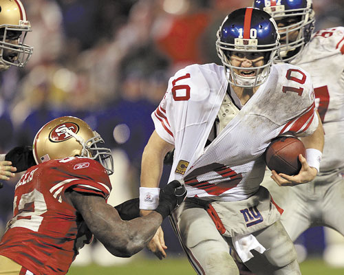 DIRTY DAY: New York Giants quarterback Eli Manning is sacked by San Francisco 49ers’ Patrick Willis during the second half of the NFC Championship game Sunday in San Francisco. Manning was sacked six times in the game.