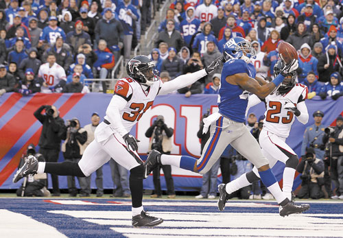 HAULING IT IN: New York Giants wide receiver Mario Manningham, center, pulls in a 27-yard touchdown pass against Atlanta Falcons strong safety James Sanders (36) and Dunta Robinson during the second half Sunday in a wild card game in East Rutherford, N.J.