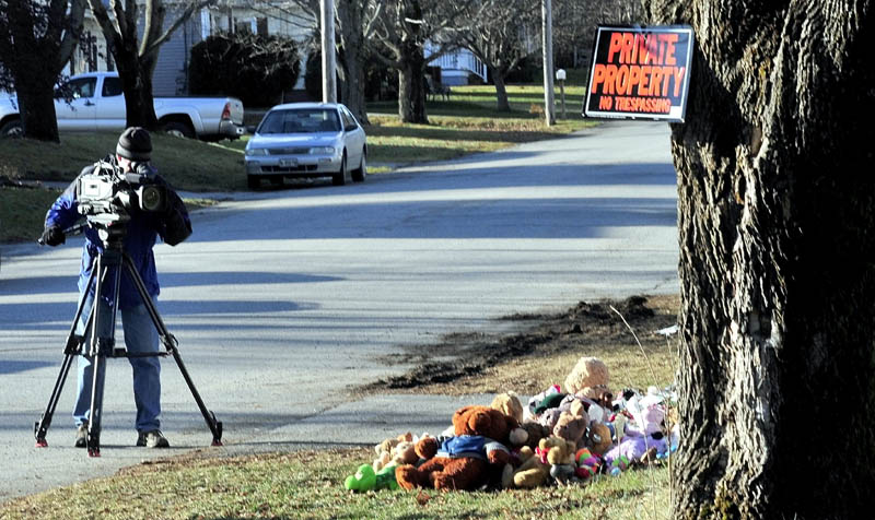 PRIVATE VS. PUBLIC INTEREST: On Monday a television news photographer films a pile of stuffed animals below a recent posting of a no trespassing sign at the home at 29 Violette Ave. in Waterville, where Ayla Reynolds was reported missing on Dec. 17.