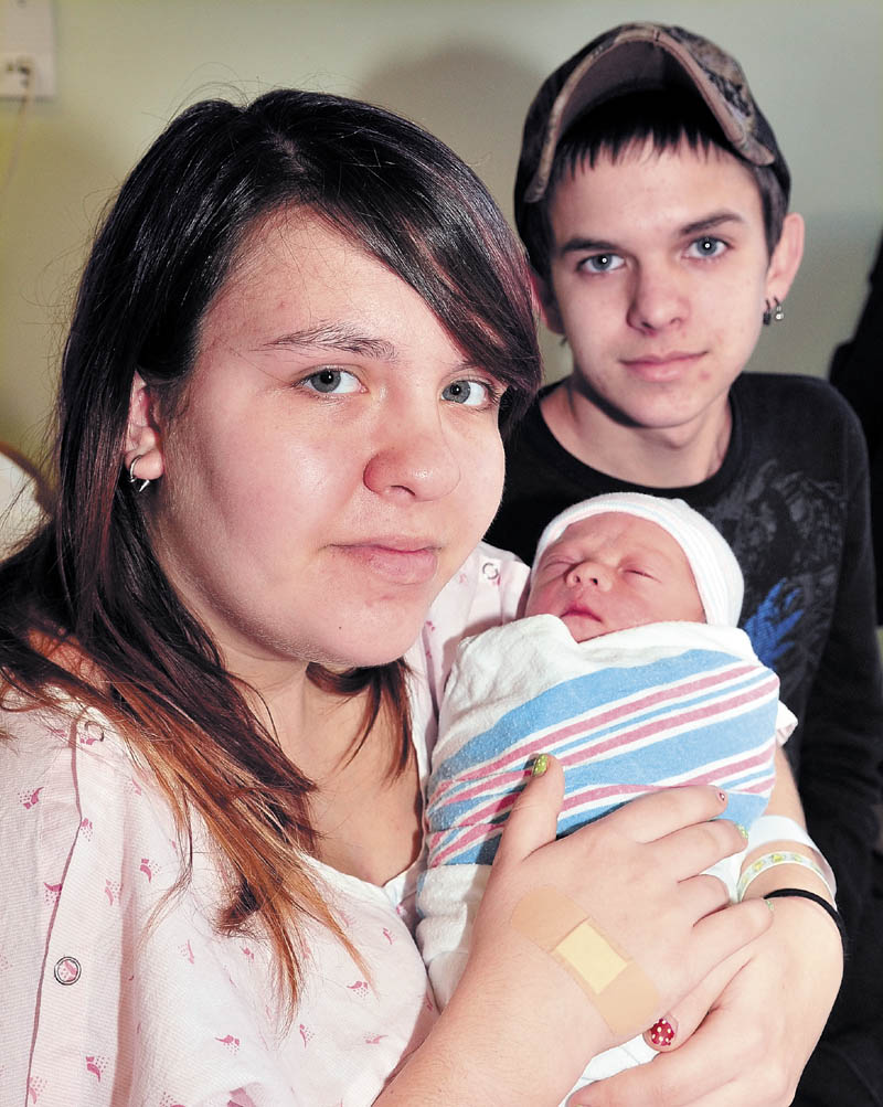 Mercedes Humphrey holds her newborn son, Cole, who was the first baby born in central Maine on Sunday, New Year’s Day. Cole arrived at 7:19 a.m. at Inland Hospital in Waterville. The boy’s father, Joey Wilshusen, looks on in the hospital room.