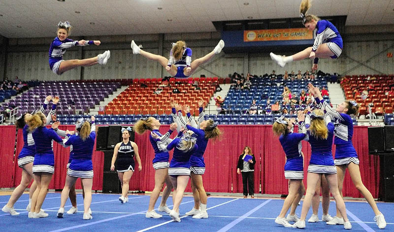 FLYING TRIO: Three Erskine Academy flyers leap into the arms of teammates during their routing at the Eastern Maine Class A cheerleading competition Saturday night at the Augusta Civic Center.
