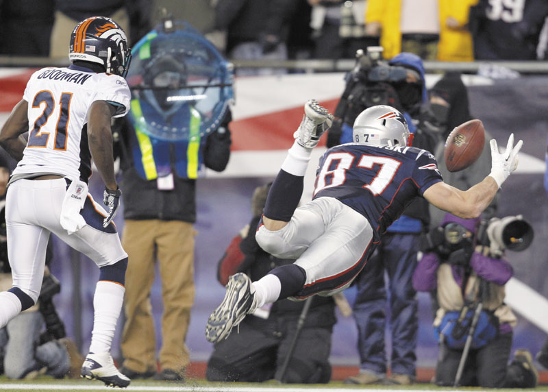 New England Patriots tight end Rob Gronkowski (87) reaches out to catch a 10-yard touchdown pass while being defended by Denver Broncos cornerback Andre' Goodman (21) during the first half Saturday in Foxborough, Mass. playoff playoffs