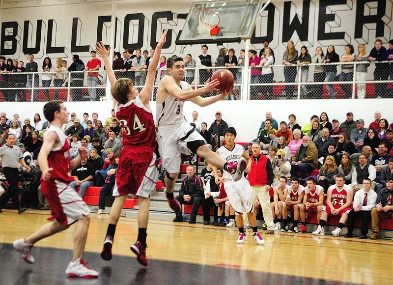 DRIVING BY: Hall-Dale’s Mike Woods, right, goes up for a shot as Wiscasset’s Travis Padilla (34) tries to stop him during a game Friday night in Penny Memorial Gym at Hall-Dale High School in Farmingdale.