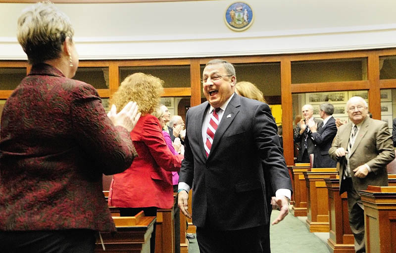 Gov. Paul LePage, right, greets Rep. Joyce Maker, R- Calais, as he walks down the aisle to give his first State of The State address on Tuesday evening at the State House in Augusta.