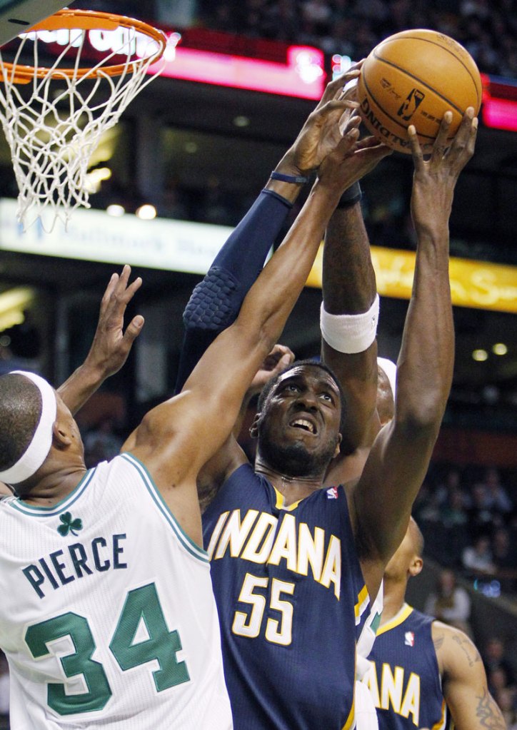 Indiana Pacers' Roy Hibbert (55) can not get the shot off against Boston Celtics' Paul Pierce (34) in the first quarter Friday in Boston.