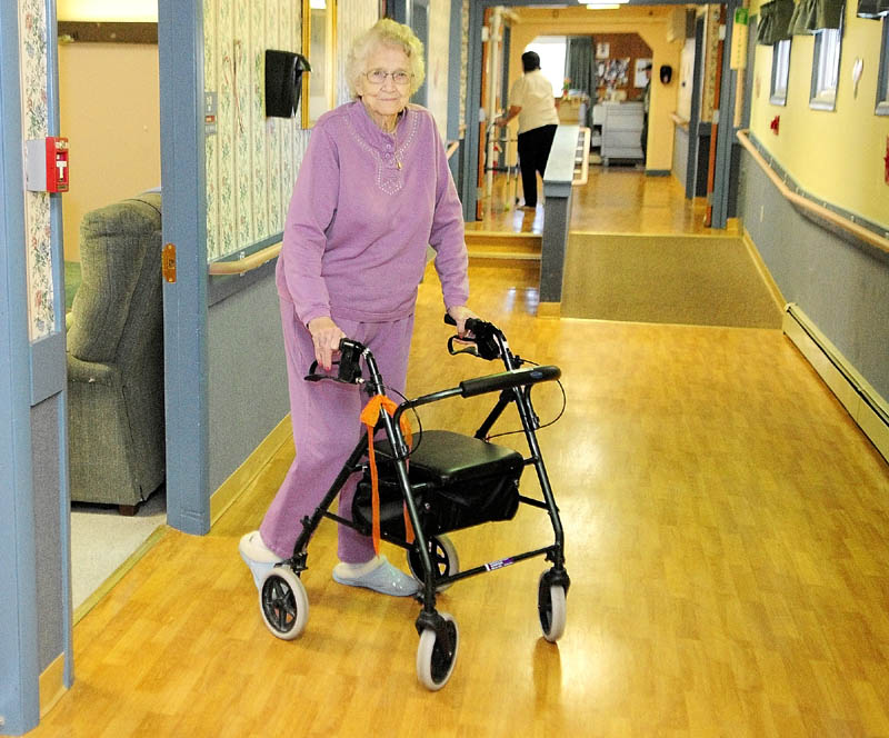 NEEDING SOME HELP: Errie Hasty, 89, walks down the hallway of the Heritage Rehabilitation & Living Center in Winthrop. Hasty moved in almost five years ago when she could no longer manage her medications by herself. Now, she’s one of the 4,291 elderly people in the state who would need to find somewhere else to live if the facilities close. Hasty is a widow, and only one of her four children lives in the area.