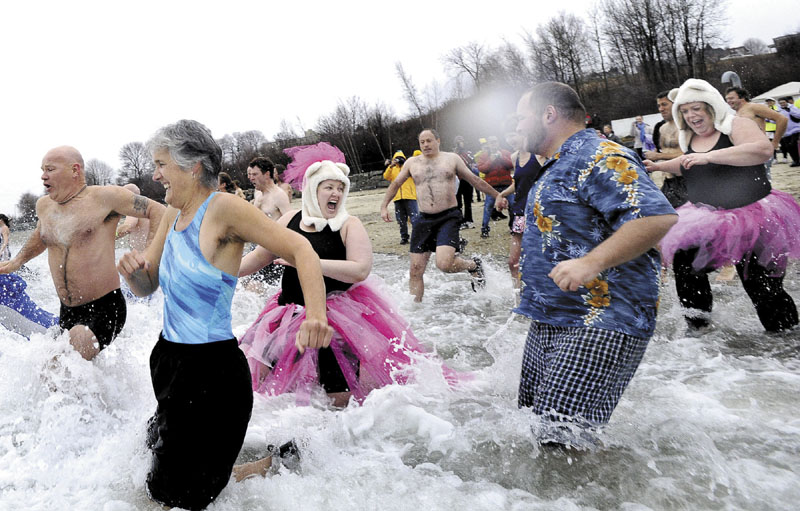 TAKING THE PLUNGE: Janine Palmer from Norwell, Mass., and Beth Dimond from Winthrop, both dressed in tutus, react to the cold water as they were among over 100 to participate in the fourth annual Polar Bear Plunge at the East End Beach in Portland.