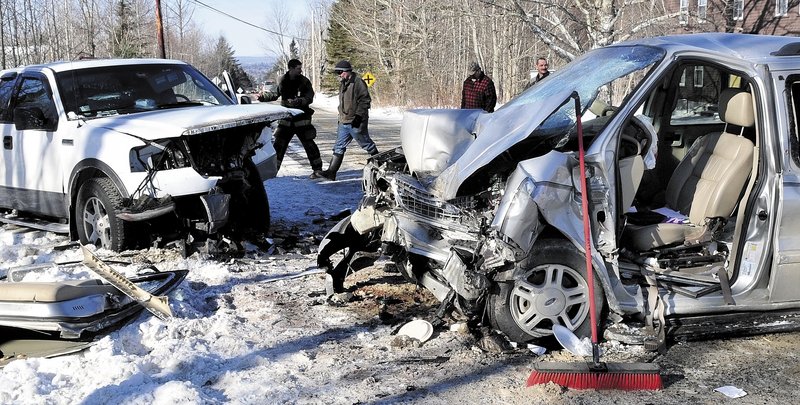 CLEANING UP: Bystanders and firefighters look over the demolished remains of two vehicles that crashed Sunday on the Warren Hill Road in Palmyra. Roger Greenlaw of Newport, operator of the van at right, was transported to Eastern Maine Medical Center by a LifeFlight of Maine helicopter.