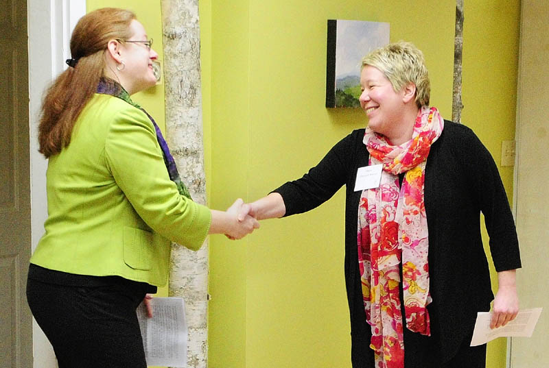 Executive Director Becky DeKeuster, left, shakes hands with Hallowell Mayor Charlotte Warren during a Tuesday news conference at the Wellness Connection of Maine dispensary in Hallowell.