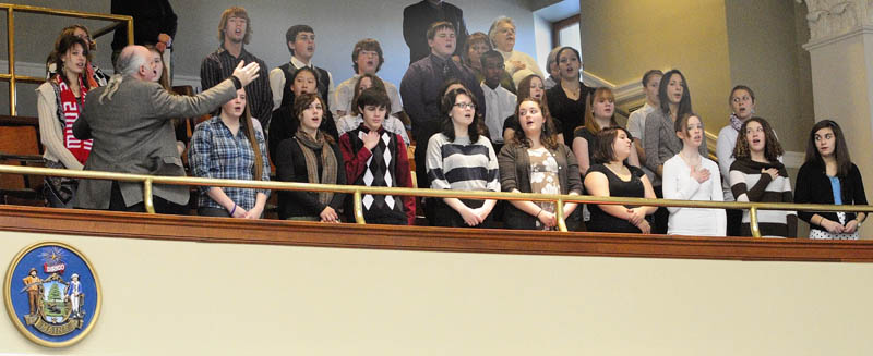 Kevin Rhein directs the Messalonskee High School Chamber Singers as they sing the National Anthem from the gallery in the House chamber on Wednesday morning at the State House in Augusta. The 30 singers, from the high school in Oakland, also sang in rotunda before the session opened at 10 a.m.
