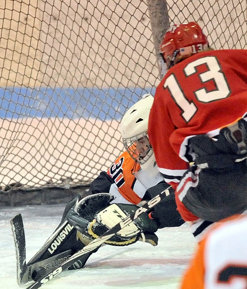 SHOT, SAVE: Skowhegan Area High School goalie Kyle Carrier (30) makes a save on a shot by Cony High School’s Galen Casey in the first period of Cony’s 2-0 win Saturday at Sukee Arena in Winslow.