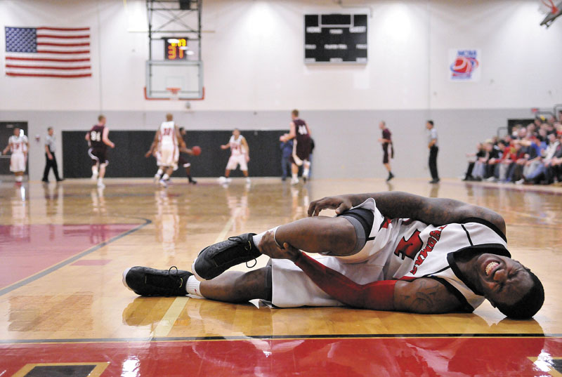 Thomas College's Stanley Greene Jr., 4, lies on the court after injuring his ankle late in the second half against University of Maine on Saturday at Farmington at Mahaney Gymnasium at Thomas College in Waterville. Thomas defeated UMF 81-73.