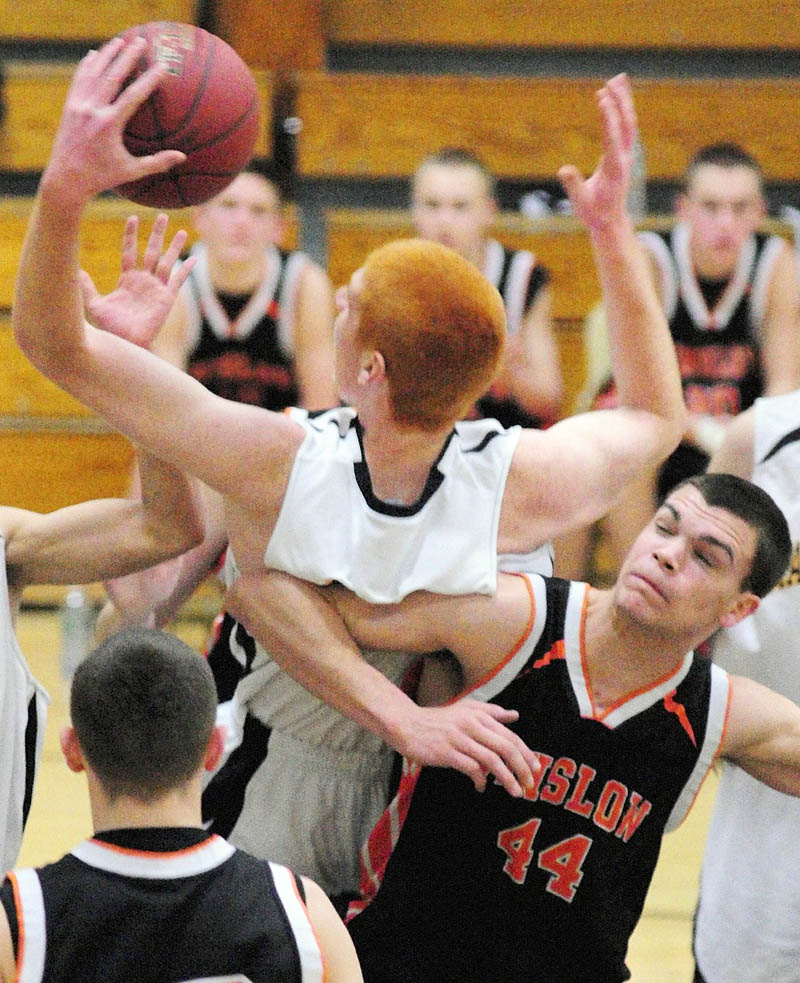 TOUGH IN THE MIDDLE: Marancook’s Kyle Boucher, top, and Winslow’s Austin Ireland (44) collide going for a rebound during a game Friday night at Maranacook Community School in Readfield.