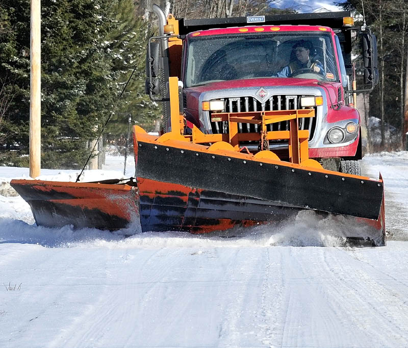 A town or Norridgewock operator of snowplow truck scrapes snow off the Oosoola Road in town last week. Officials throughout the central Maine region are reporting that the high amount of freezing rain an