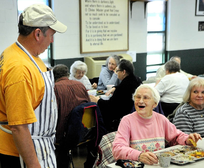 Cook Steve Dodge, left, chats with Lila Sciuk on Wednesday as the Winthrop Hot Meal Kitchen ended a seven-month hiatus and resumed serving daily mid-day meals at St. Francis Xavier Church Hall.