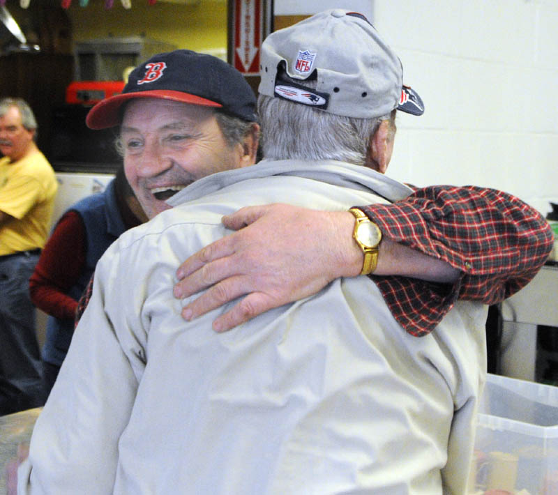 Volunteer Joe Cook, left, hugs Jack Everett as he comes in for lunch on Wednesday at the Winthrop Hot Meal Kitchen in the St. Francis Xavier Church Hall.