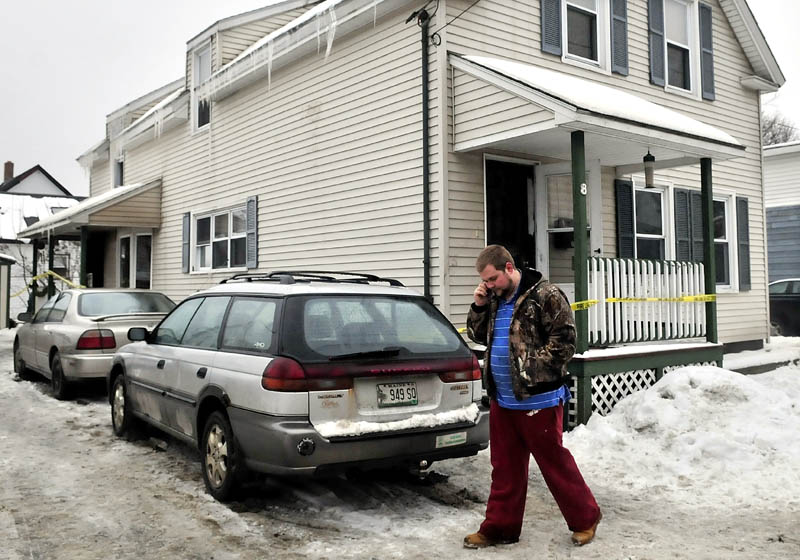 IN SHOCK: Homeowner Nicholas White speaks on a cellphone outside his home on King Street in Waterville after fire destroyed the interior and belongings shortly after midnight on Monday. White and occupant Jacob Reid said they were in shock later Monday as investigators searched inside for the cause.