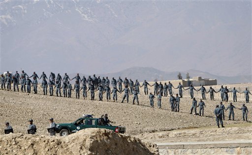 Afghan policemen form a line outside American military base on Thursday during an anti-U.S. demonstration in Mehterlam, Laghman province east of Kabul, Afghanistan. The police fired shots in the air to disperse hundreds of protesters who tried to break into the base to vent their anger over this week's Quran burnings incident.