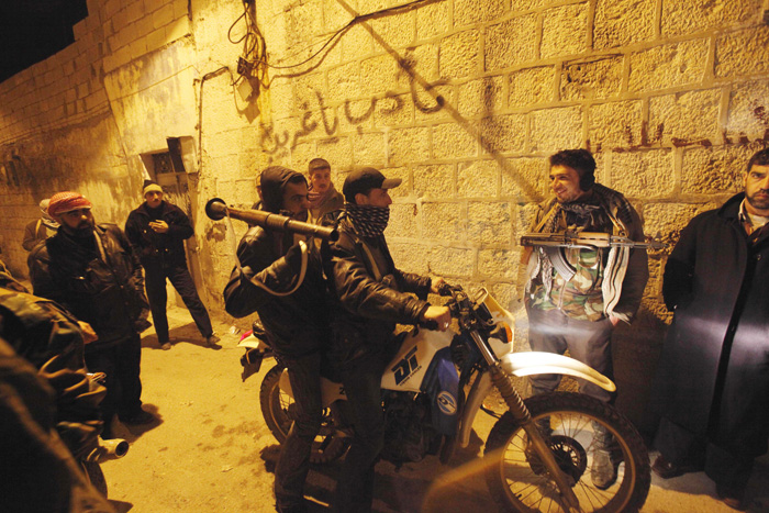 Syrian rebels gather in an alley on Sunday as they secure a demonstration site in Idlib.