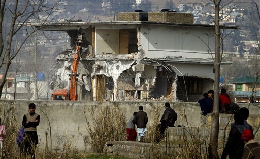 Local residents watch as authorities use heavy machinery to demolish the compound of Osama bin Laden in Abbottabad, Pakistan.