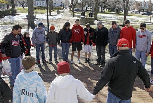 A group of students and parents pray for the shooting victims on the town square in Chardon, Ohio, today.