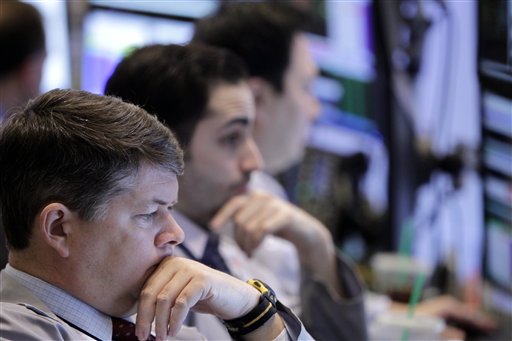 Traders work on the floor at the New York Stock Exchange in New York today as the Dow Jones industrial average crossed the 13,000 mark, and quickly fell back.