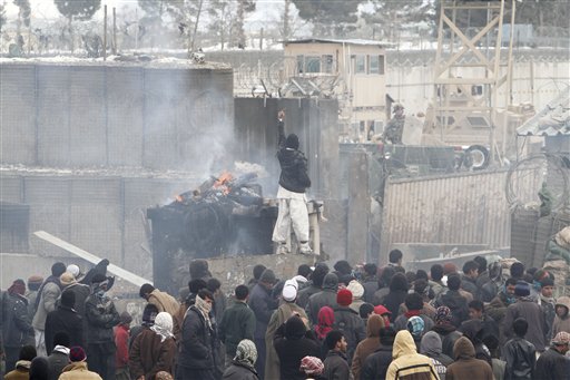 An Afghan protester points toward a U.S. soldier during a demonstration in Bagram, north of Kabul, Afghanistan, today. More than 2,000 angry Afghans, some firing guns in the air, protested against the improper disposal and burning of Qurans and other Islamic religious materials.
