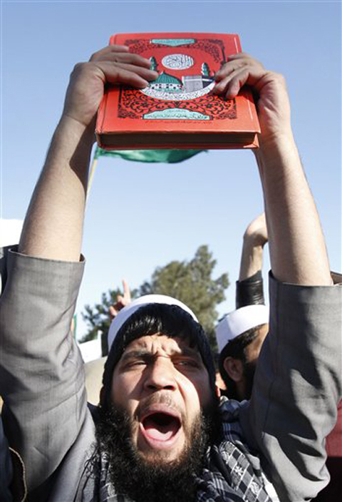An Afghan protester holds a copy of Islam's holy book Quran as he shouts slogans during an anti-US demonstration in Jalalabad, east of Kabul, Afghanistan, on Wednesday.