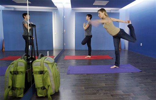 Travelers Maria Poole, right, and Lindsey Shepard, practice yoga at San Francisco International Airport's new Yoga Room recently. The quiet, dimly lit studio officially opened last week in a former storage room. Airport officials believe it is the world's first airport yoga studio.