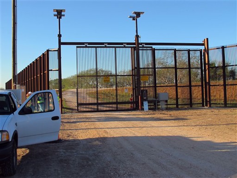In this Jan. 27 photo, government contractors test a new gate in the border fence in Brownsville, Texas. A year after completion of the border fence the government is installing 44 gates in South Texas. (AP Photo/Chris Sherman)