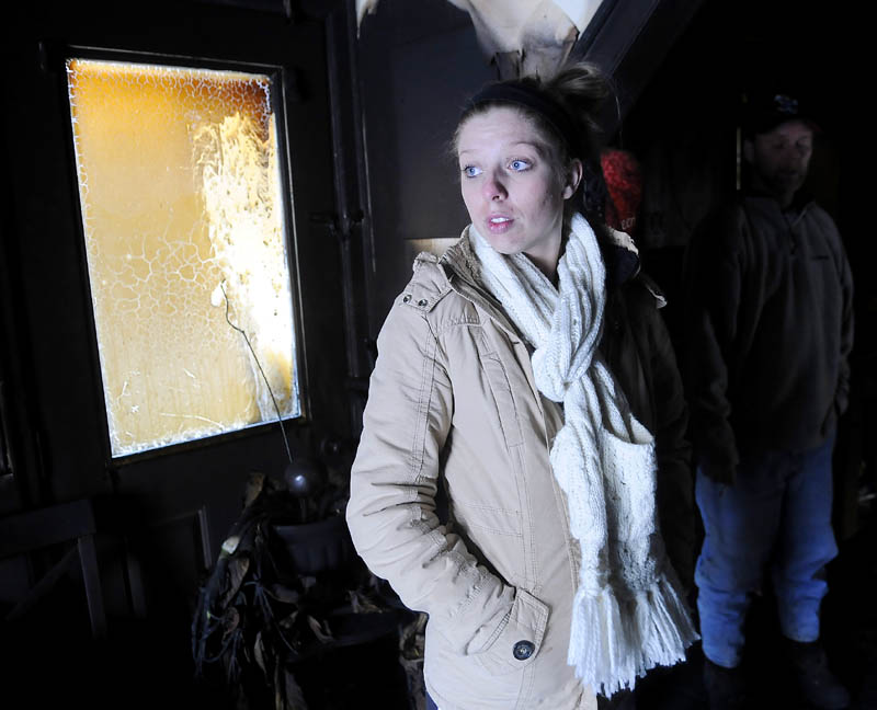 Siera Boucher stands in the burned out kitchen Monday at her Readfield home. Boucher, 21, and her parents Kevin and Noreen Boucher, escaped their burning home Sunday night without injury. The home was gutted by fire.